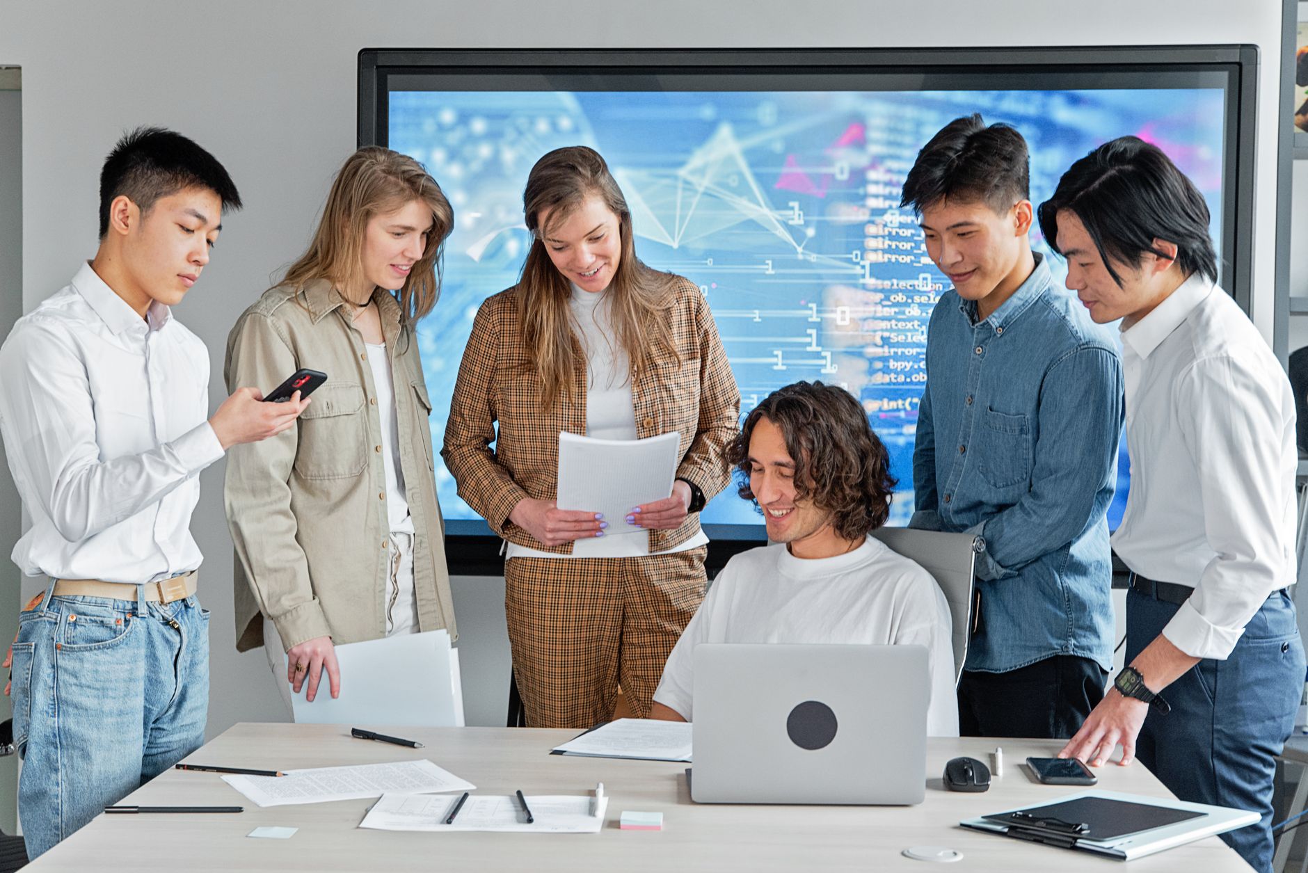 Diverse team collaborating in a modern office with technology.