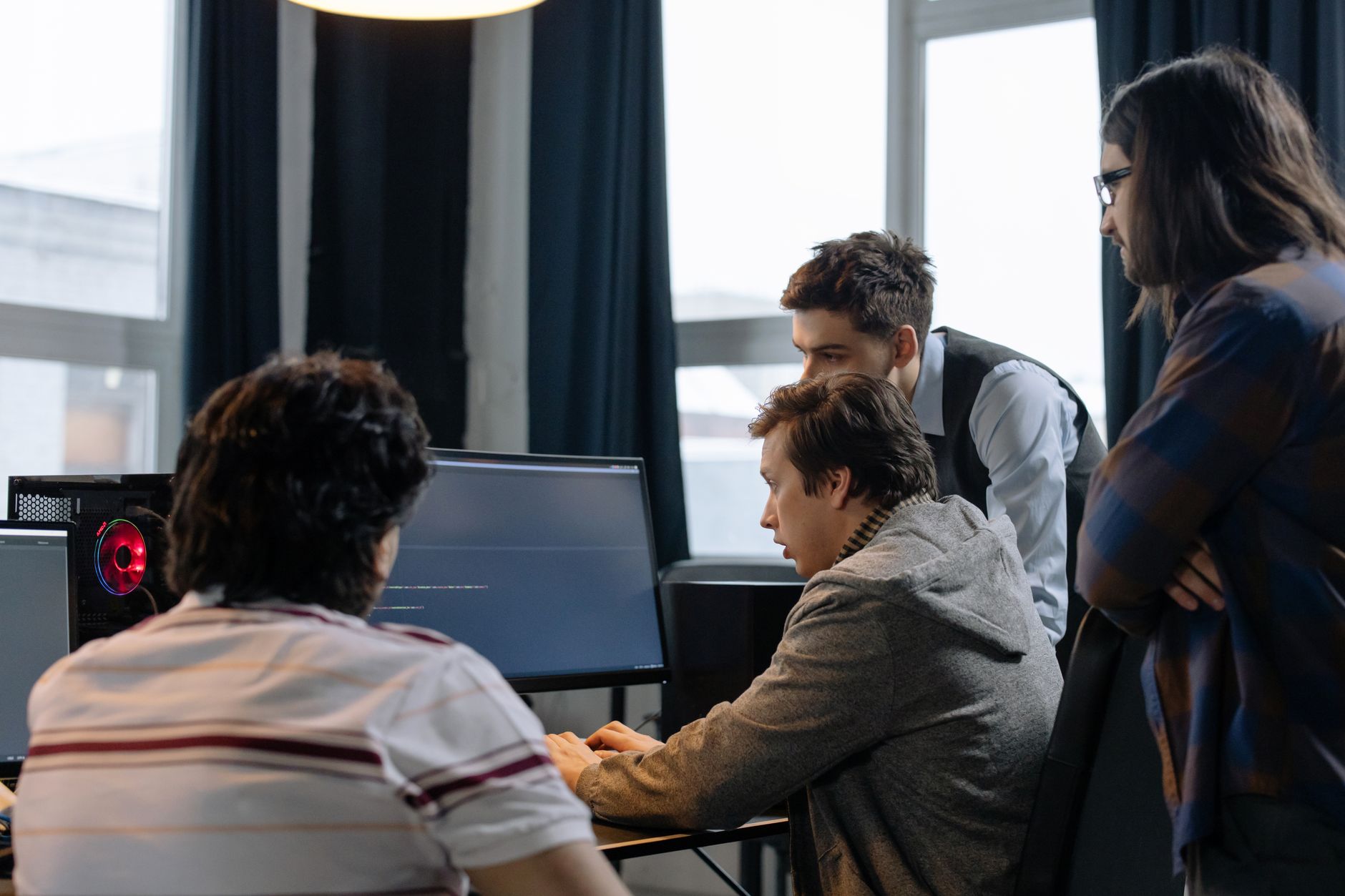 Group of developers working together on a computer programming project indoors.