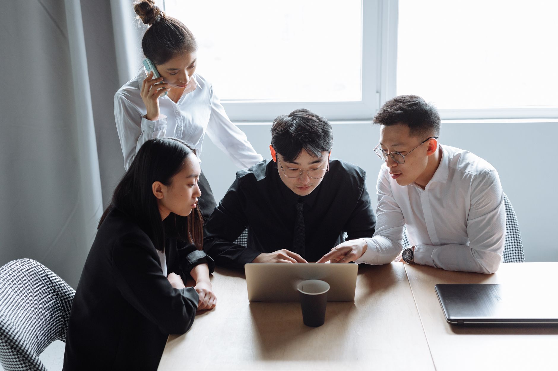 Business team brainstorming in an office setting with laptops and teamwork spirit.